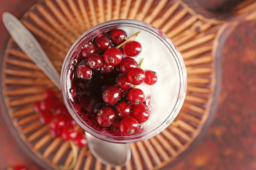 Glass jar with delicious rice pudding and currants on board, closeup
