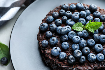 Delicious blueberry chocolate cake on plate, closeup