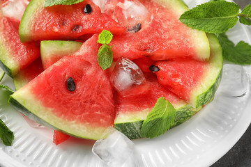 Sweet watermelon slices and ice cubes on plate, closeup