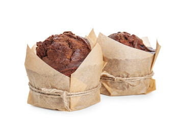Sweet tasty muffins wrapped in paper on white background