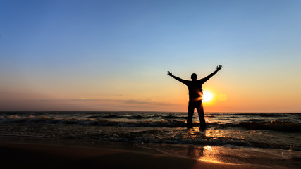 Fototapeta premium silhouette of a man at dawn / beach wilderness dawn