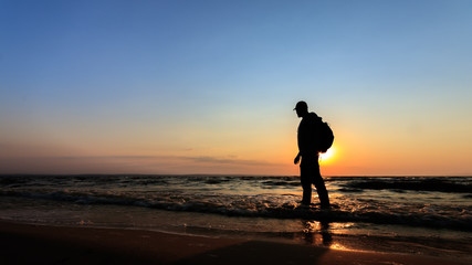 Fototapeta na wymiar silhouette of a man at dawn / beach wilderness dawn