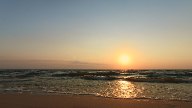 Fototapeta sunrise on the water / Early summer morning bright sky Beach