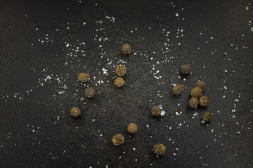 black pepper and salt on a black background / background photo kitchen theme small depth of field