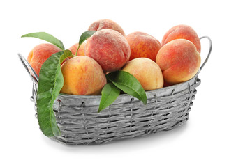 Basket with fresh peaches on white background