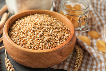 Bowl with raw wheat on table, closeup