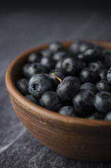 Blueberries in the bowl on a black slate
