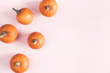 Autumn composition. Pumpkins on pastel pink background. Autumn, fall, halloween concept. Flat lay,...