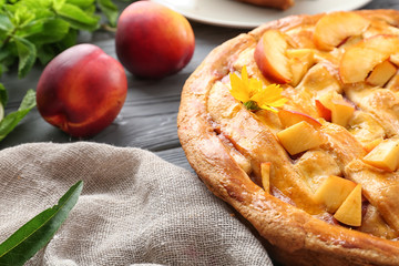 Tasty homemade peach pie on wooden table, closeup