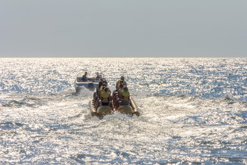 happy vacationers tourists ride an inflatable banana in the sea