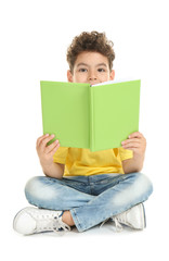 Cute little boy reading book on white background © Pixel-Shot