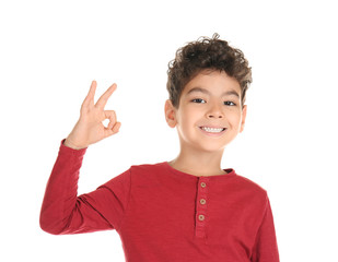 Cute little boy showing OK gesture on white background