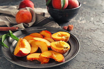 Plate with sliced peaches on grunge table