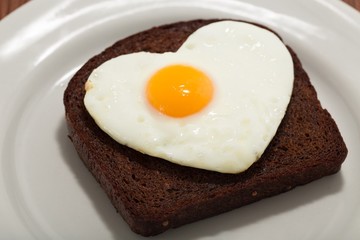 Slice of Bread with Fried Egg in the Shape of Heart on the Plate