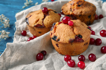Tasty cranberry muffins on napkin