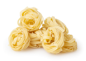 Uncooked nests of tagliatelle pasta isolated on white background with clipping path