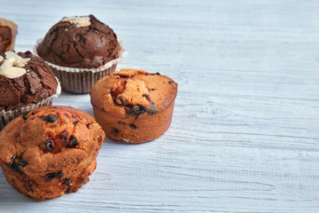 Tasty muffins on white wooden table