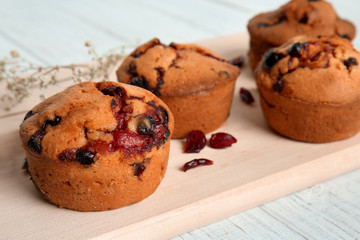 Tasty cranberry muffins on board, closeup