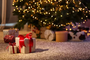 Foto op Plexiglas Mooie kerstcadeaudozen op de vloer in de buurt van dennenboom in de kamer © Pixel-Shot
