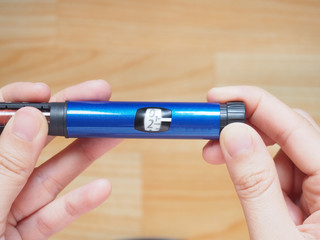 Diabetes patient turn knob on end of insulin pen and dial up correct insulin dose for injection. Scale window on pen syringe showing number of units dose. Medical equipment is easy to self injection.