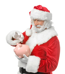 Santa Claus putting coin into piggy bank on white background