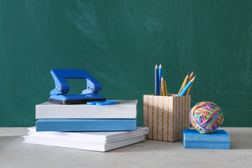 School stationery and books on table near chalkboard