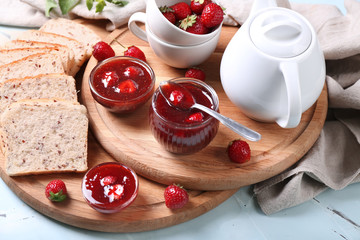 Slices of bread and delicious strawberry jam on board