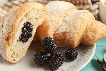 Tasty croissants with berry jam on plate, closeup