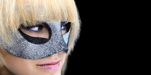 
closeup portrait of young  woman with masquerade mask, isolated on black 
background, banner format