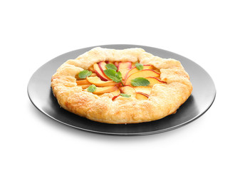 Plate with delicious peach galette on white background