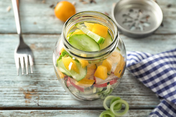 Delicious vegetable salad in mason jar on wooden table
