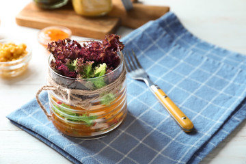 Delicious vegetable salad in mason jar on table