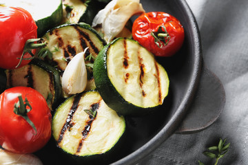 Tasty grilled zucchini and tomatoes in pan, closeup