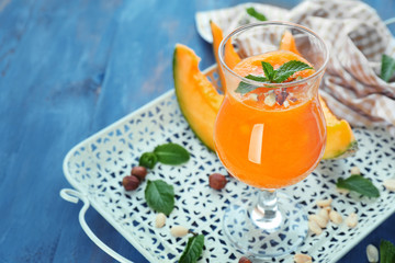 Glass of fresh melon smoothie on tray
