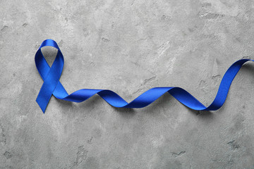Blue ribbon on grey background. Cancer concept