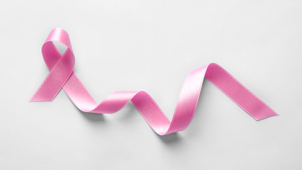 Fototapeta na wymiar Pink ribbon on light background. Breast cancer concept