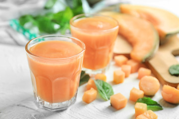 Glasses with delicious melon smoothie on white table