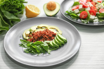 Plate with healthy fresh salad on light table