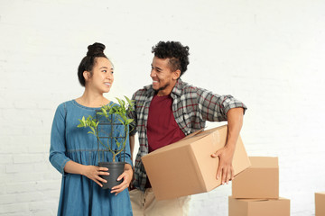 Happy interracial couple unpacking boxes in room. Moving into new house