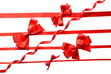 Red ribbons with beautiful bows on white background