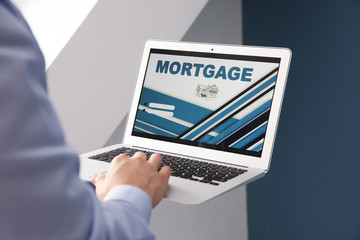 Man using laptop to pay mortgage loan online in office
