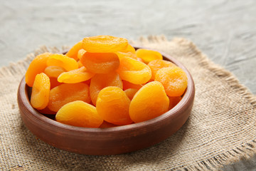 Plate with dried apricots on table