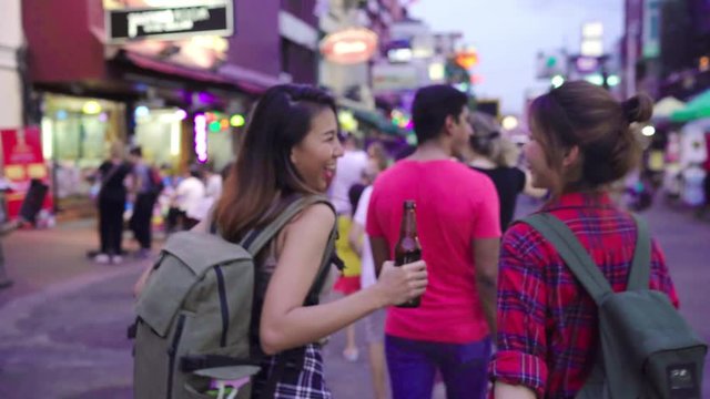 Traveler backpacker Asian women lesbian lgbt couple travel in Bangkok, Thailand. Female drinking alcohol or beer at The Khaosan Road the most famous street in Bangkok.