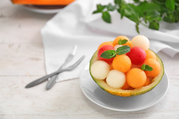 Bowl with fresh melon and watermelon balls on light table