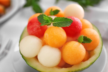 Bowl with fresh melon and watermelon balls on table, closeup