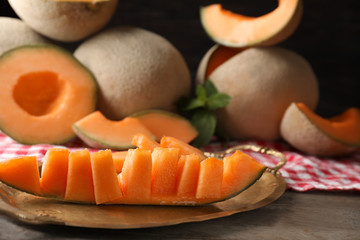 Tray with cut ripe melon on table
