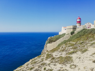 Fototapeta na wymiar Lighthouse over cliff in Sagres, Portugal.