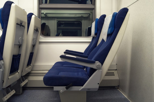 Empty Chairs In The Train Side View. The Interior Of The Railway Wagon, Carriage With Blue Seats