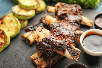 Delicious grilled ribs on slate plate, closeup