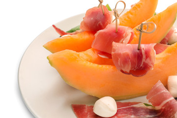 Delicious melon with prosciutto and mozzarella cheese on plate, closeup